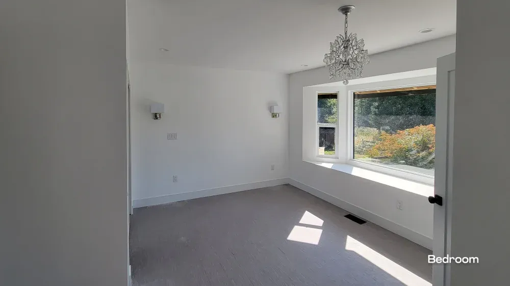 Master bedroom remodel by PCC Renovations featuring a large custom bay window and an elegant crystal chandelier.
