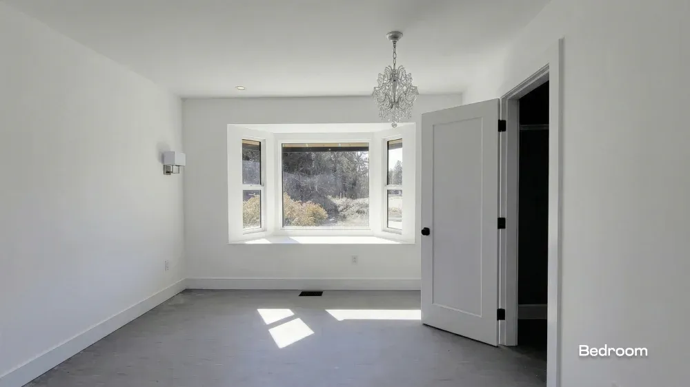 Bedroom interior renovation with new grey flooring, a walk-in closet, and a bay window by Pacific Coast Contracting.