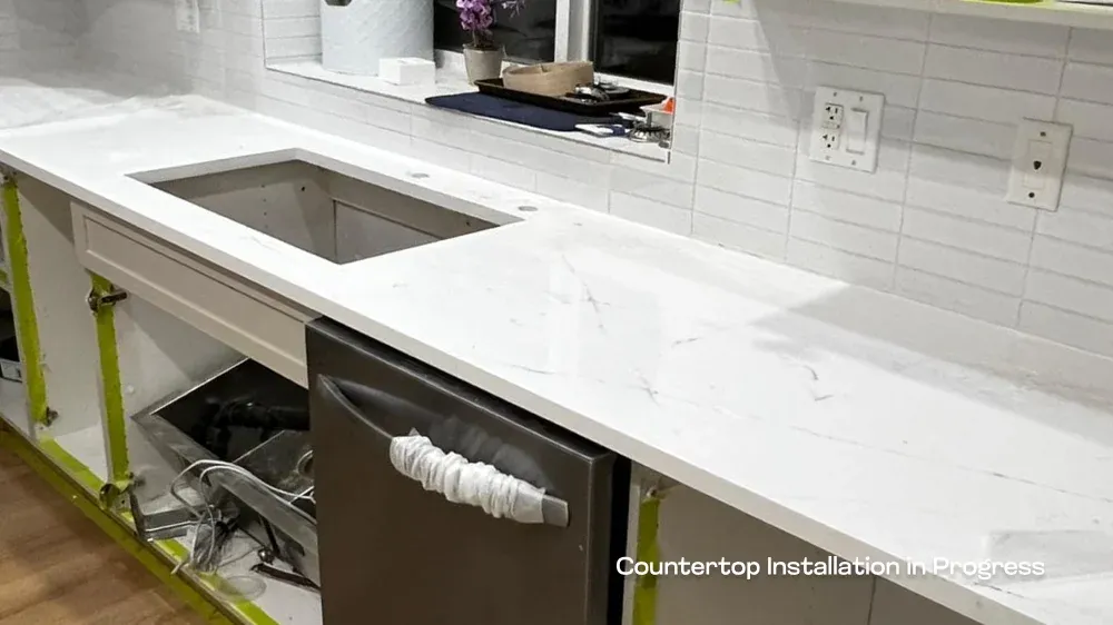 White quartz countertop installation in progress showing a custom sink cutout and classic subway tile backsplash.