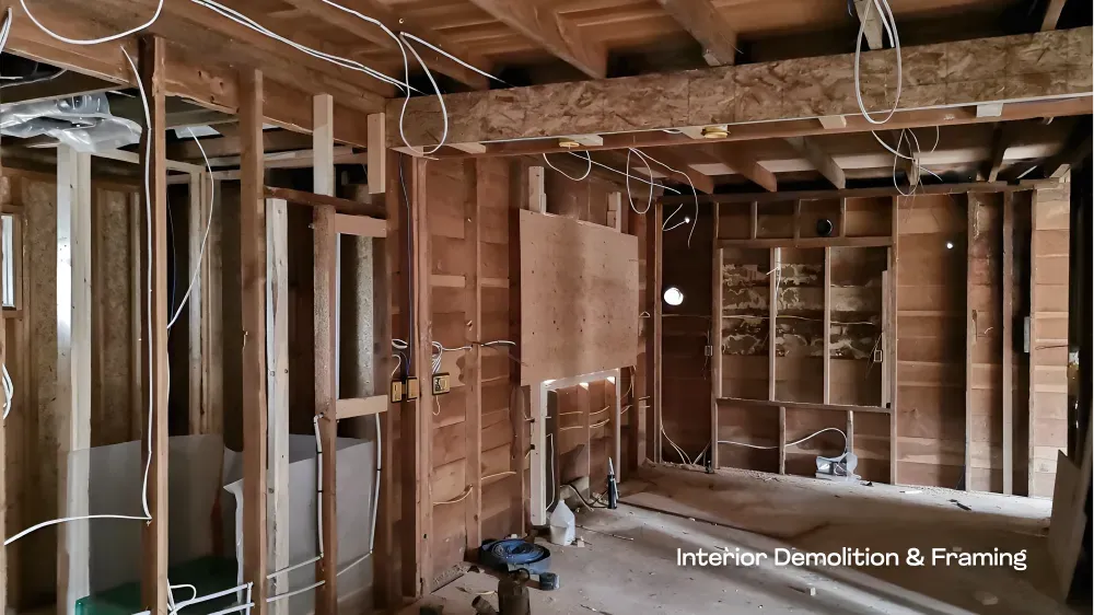 A residential renovation project in progress, showing exposed wall studs and framing, managed by PCC Vancouver — before