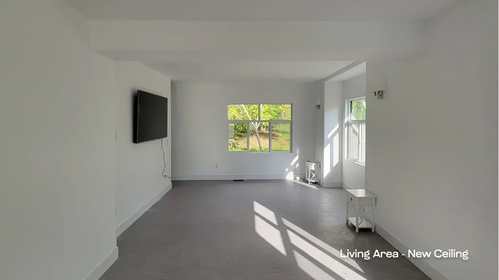 Living room renovation with updated white ceiling and modern wall sconces by Pacific Coast Contracting. — after